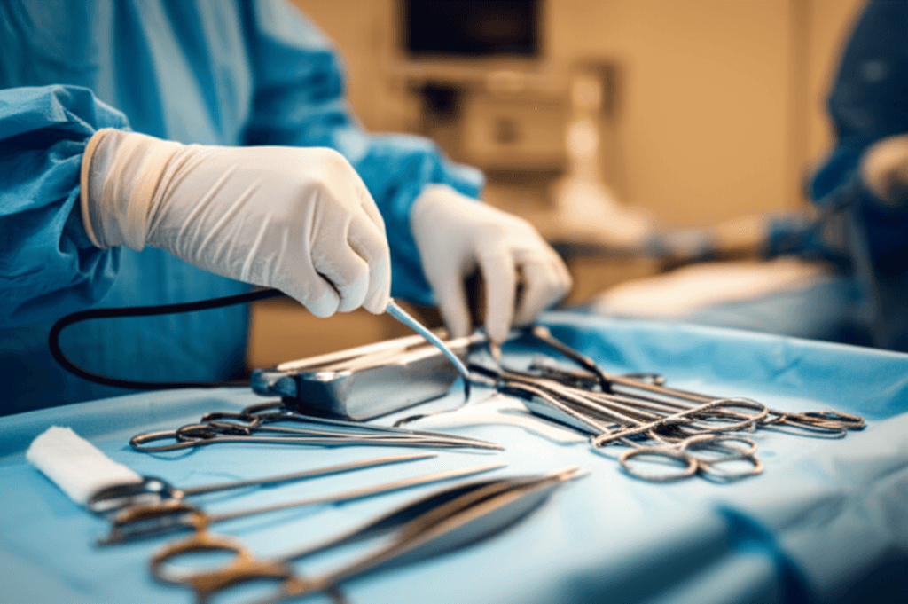 Surgeon preparing minimally invasive instruments for hernia repair